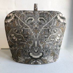 Tehtte , tevarmer i bomuldsstof i gr og beige farver og tehtten har et  motiv af blomster.