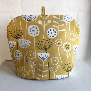 Tehtte , tevarmer i gult bomuldsstof med motiver af blomster og blade.