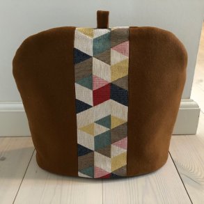 Tehtte/ tevarmer i brun uld med et midterstykke med tre-og firkantet stof.