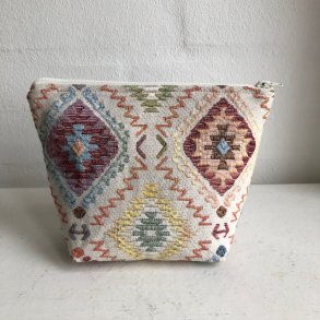 Kosmetikpung , kosmetiktaske , makeup taske i gobelin med en lys bund og et motiv i pastel farver.