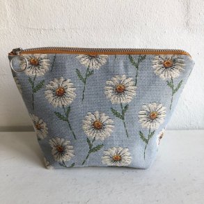 Kosmetikpung , makeruptaske i gobelin med lysebl bund og motiver af sm margueritter.