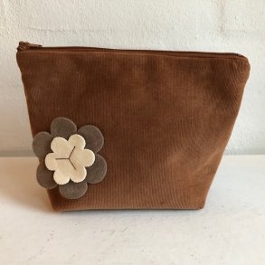 Kosmetikpung-makeuptaske i gyldent brunt fljl med blomst.
