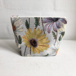 Kosmetikpung-makeuptaske i lyst stof med marguritter.