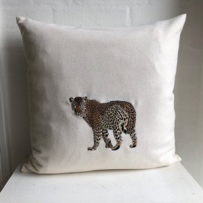 Uldpude med broderet leopard.