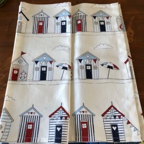 Bordlber i lyst bomuld med motiver af farvestrlende badehuse.