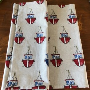 Bordlber i lyst/ beige stof med motiver af sm kuttere.