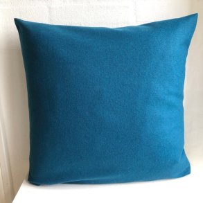 Designpude i ensfarvet petroliumsfarvet uld