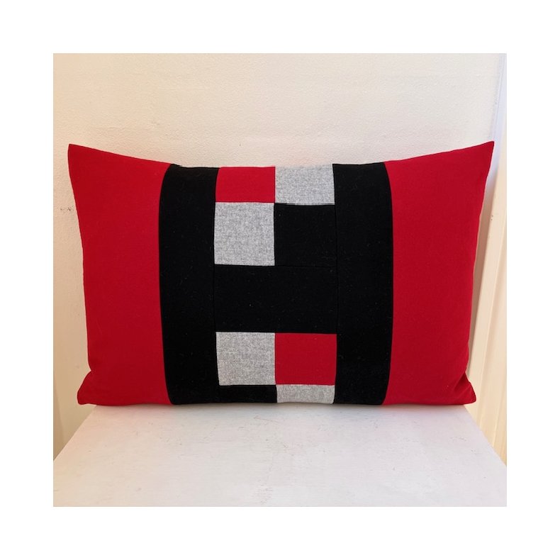 H-pude med r�de sider og sort H i 100% uld.