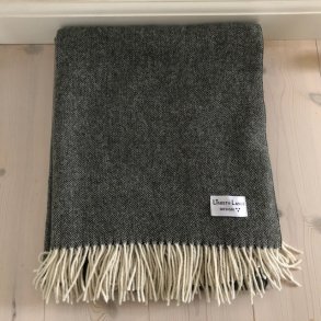 Plaid / tppe i grn recycled uld med lyse frynser.