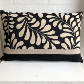 Pude i gobelin med sort bund og lyse blade kombineret med uld.