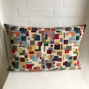 Pude i gobelin med en lys bund og motiver i mange farver.