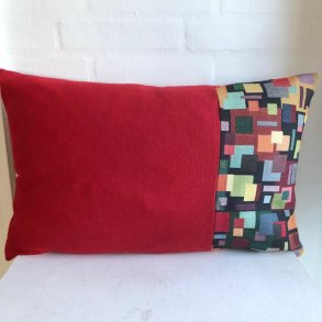 Pude i rd uld med en gobelin i den ene side med et mnster af firkanter.