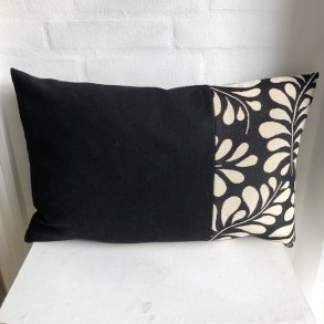 Pude i sort uld med sort gobelin med lyse drbeformede offwhite blade i de ene side.