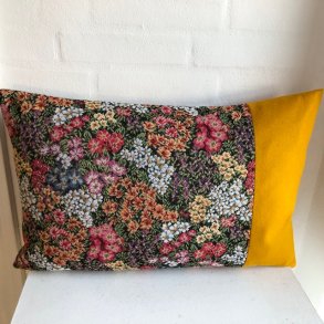 Pude sofapude designpude i blomstret stof med gul uld i siden.
