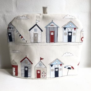 Tehtte / tevarmer i lyst bomuldsstof med motiver af sm farvestrlende badehuse.