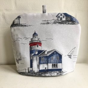 Tehtte / tevarmer i lys grt stof med fyrtrn og skibe..
