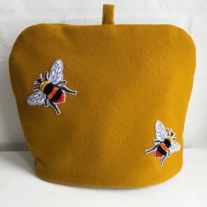  Tehtte / tevarmer i karrygul uld med bier.